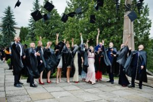 Happy university graduates throwing their graduation caps into the air.